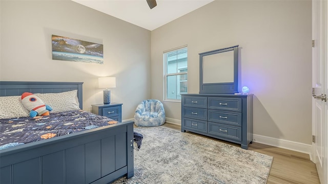 bedroom featuring baseboards, wood finished floors, and ceiling fan