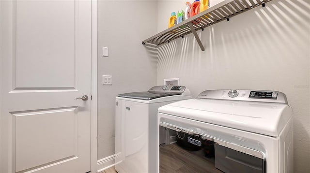laundry area with washing machine and dryer and wood finished floors