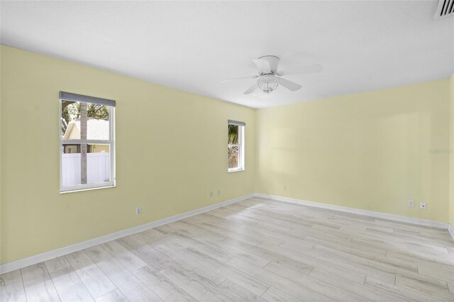 3263 Woodberry Ln Lot 15, Sarasota, FL 34231 - unfurnished room with healthy amount of natural light, light wood-type flooring, ceiling fan, and baseboards