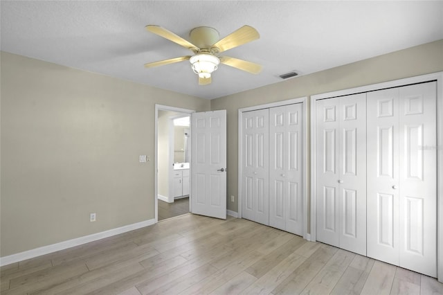 3263 Woodberry Ln Lot 15, Sarasota, FL 34231 - unfurnished bedroom with multiple closets, baseboards, light wood finished floors, and a ceiling fan