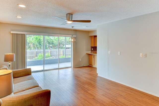 7719 9th Avenue Dr NW, Bradenton, FL 34209 - living room featuring ceiling fan, light wood finished floors, baseboards, recessed lighting, and a textured ceiling