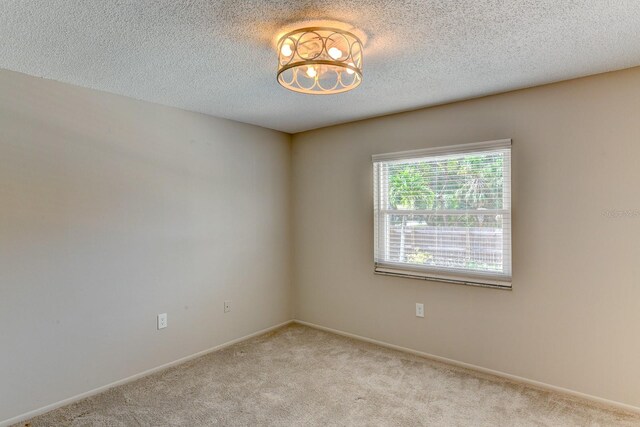 7719 9th Avenue Dr NW, Bradenton, FL 34209 - unfurnished room with carpet flooring, a textured ceiling, baseboards, and a chandelier