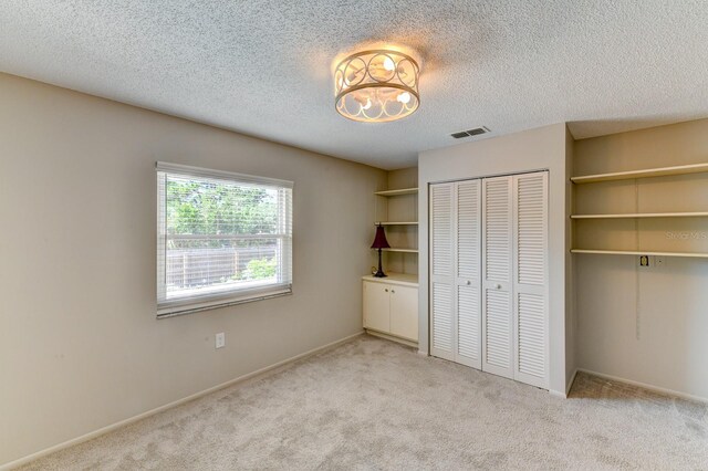7719 9th Avenue Dr NW, Bradenton, FL 34209 - unfurnished bedroom featuring light colored carpet, a closet, a textured ceiling, and baseboards
