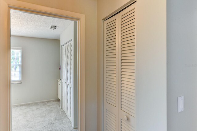 7719 9th Avenue Dr NW, Bradenton, FL 34209 - hallway with carpet flooring, a textured ceiling, and baseboards