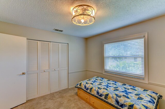 7719 9th Avenue Dr NW, Bradenton, FL 34209 - bedroom featuring carpet floors, a closet, and a textured ceiling