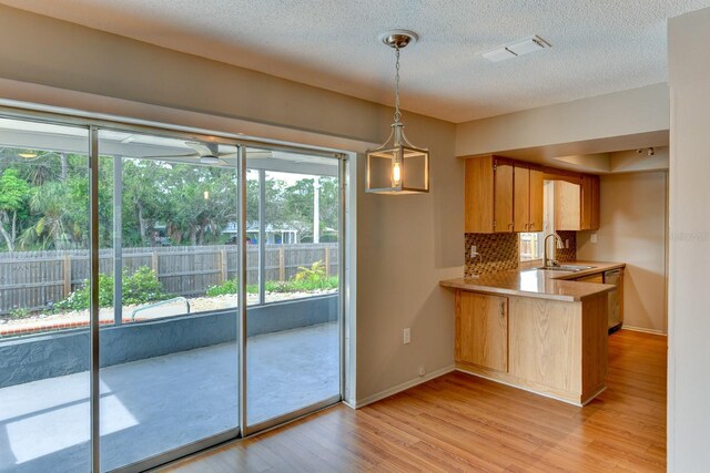 7719 9th Avenue Dr NW, Bradenton, FL 34209 - kitchen with a sink, light countertops, light wood-style floors, plenty of natural light, and a textured ceiling