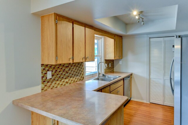 7719 9th Avenue Dr NW, Bradenton, FL 34209 - kitchen featuring a sink, a raised ceiling, appliances with stainless steel finishes, light countertops, and a peninsula