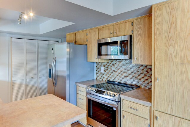 7719 9th Avenue Dr NW, Bradenton, FL 34209 - kitchen featuring appliances with stainless steel finishes, tasteful backsplash, light brown cabinetry, light countertops, and track lighting