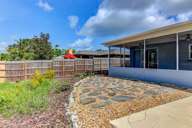 7719 9th Avenue Dr NW, Bradenton, FL 34209 - fenced backyard featuring ceiling fan, a patio area, and a sunroom