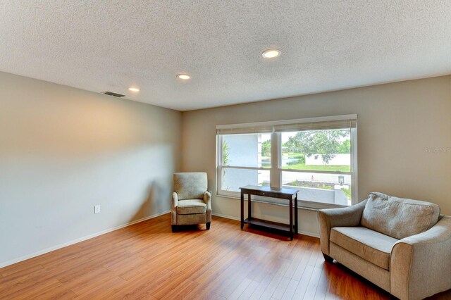 7719 9th Avenue Dr NW, Bradenton, FL 34209 - sitting room featuring wood finished floors, healthy amount of natural light, recessed lighting, a textured ceiling, and baseboards