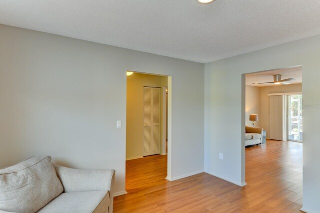 7719 9th Avenue Dr NW, Bradenton, FL 34209 - sitting room featuring light wood-style floors, a textured ceiling, and baseboards