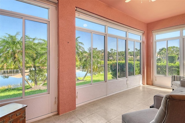 4322 Reflections Pkwy, Sarasota, FL 34233 - sunroom / solarium featuring tile patterned flooring, a water view, plenty of natural light, and a textured wall