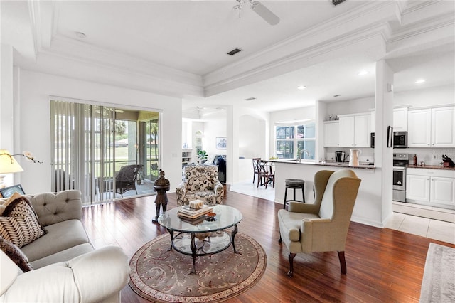 315 Heritage Isles Way, Bradenton, FL 34212 - living room featuring wood finished floors, a ceiling fan, crown molding, a tray ceiling, and recessed lighting
