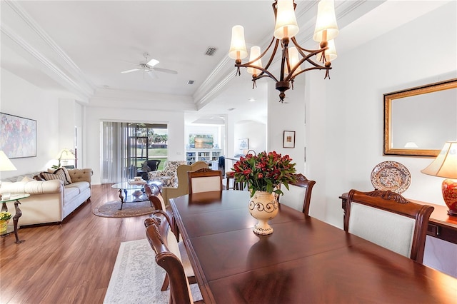 315 Heritage Isles Way, Bradenton, FL 34212 - dining room with a raised ceiling, wood finished floors, a ceiling fan, ornamental molding, and a chandelier