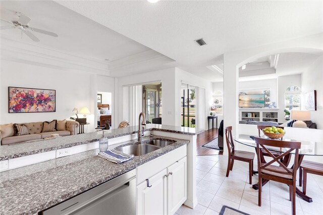 315 Heritage Isles Way, Bradenton, FL 34212 - kitchen with a tray ceiling, open floor plan, a sink, stainless steel dishwasher, and stone counters
