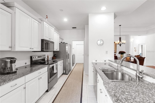 315 Heritage Isles Way, Bradenton, FL 34212 - kitchen featuring appliances with stainless steel finishes, a sink, a chandelier, white cabinetry, and light tile patterned flooring
