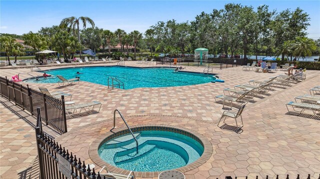 315 Heritage Isles Way, Bradenton, FL 34212 - community pool with fence, a patio, view of wooded area, and a community hot tub