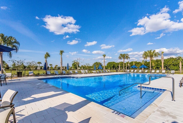 community pool with fence and a patio