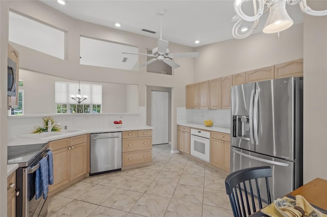 6664 Deering Cir, Sarasota, FL 34240 - kitchen with stainless steel appliances, light brown cabinets, a chandelier, tasteful backsplash, and a high ceiling