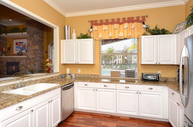 5681 Bidwell Pkwy Unit 102, Sarasota, FL 34233 - kitchen with stainless steel appliances, ornamental molding, a sink, white cabinetry, and wood finished floors