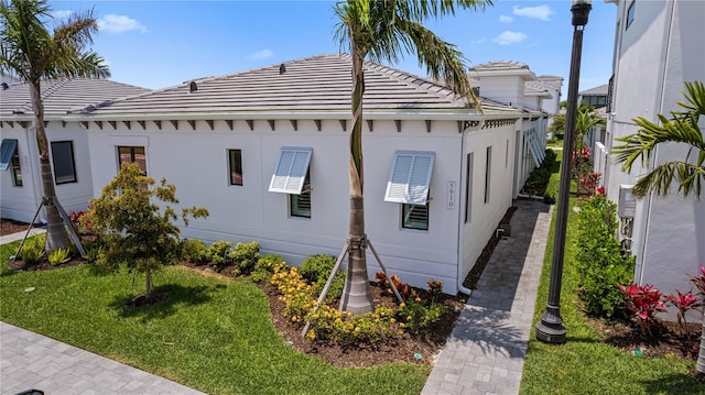 5910 Red Mangrove Ln, Bradenton, FL 34210 - view of home's exterior featuring a tile roof, stucco siding, and a lawn