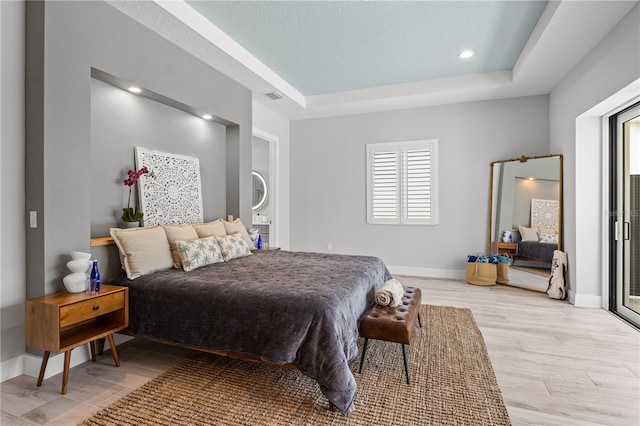 5910 Red Mangrove Ln, Bradenton, FL 34210 - bedroom with light wood-style flooring, a tray ceiling, baseboards, and recessed lighting