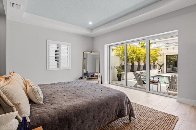5910 Red Mangrove Ln, Bradenton, FL 34210 - bedroom featuring a raised ceiling, access to exterior, recessed lighting, wood finished floors, and a textured ceiling