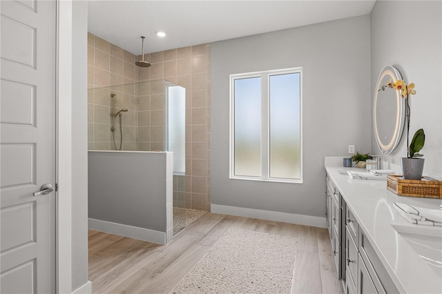 5910 Red Mangrove Ln, Bradenton, FL 34210 - bathroom with a walk in shower, wood finished floors, double vanity, baseboards, and recessed lighting