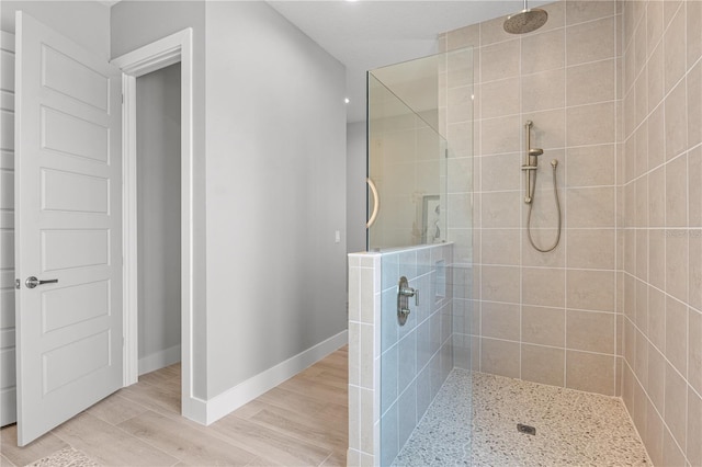 5910 Red Mangrove Ln, Bradenton, FL 34210 - bathroom featuring a tile shower, baseboards, and wood finished floors