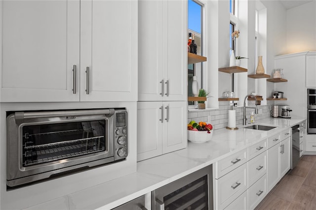 5910 Red Mangrove Ln, Bradenton, FL 34210 - bar area featuring a sink, stainless steel appliances, tasteful backsplash, light wood-style floors, and wine cooler