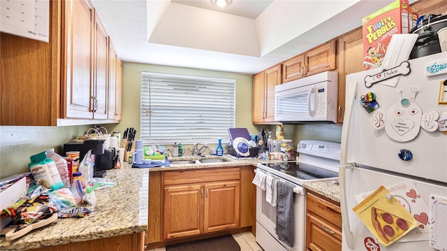 5964 7th Ave W Unit 5964, Bradenton, FL 34209 - kitchen featuring white appliances, a sink, brown cabinetry, light stone countertops, and light tile patterned floors