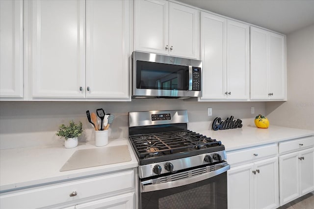 kitchen with appliances with stainless steel finishes, light countertops, and white cabinets