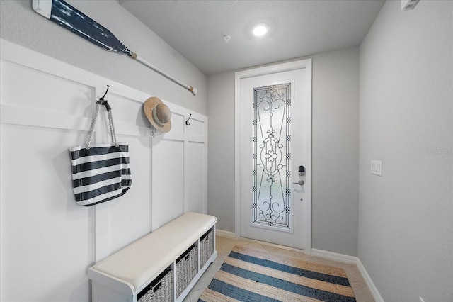 mudroom featuring baseboards and light tile patterned flooring
