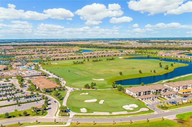 aerial view of residential area featuring a nearby body of water and a golf course