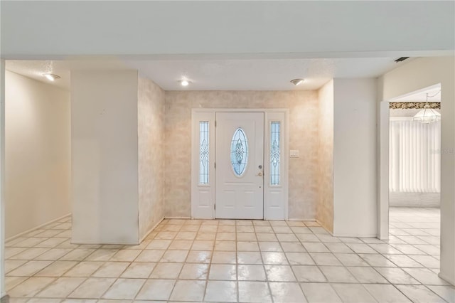 foyer entrance featuring light tile patterned floors and baseboards