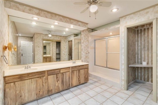 full bathroom featuring ceiling fan, wallpapered walls, an enclosed shower, double vanity, and tile patterned floors