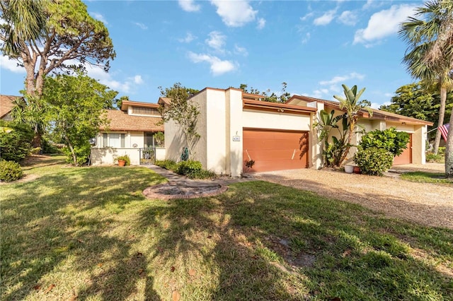 6203 Courtside Dr Unit 21, Bradenton, FL 34210 - mid-century inspired home featuring stucco siding, a front yard, driveway, and an attached garage