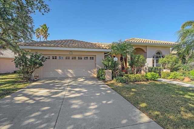 4978 Cedar Oak Way, Sarasota, FL 34233 - mediterranean / spanish-style house featuring concrete driveway, a garage, stucco siding, a tile roof, and a front lawn