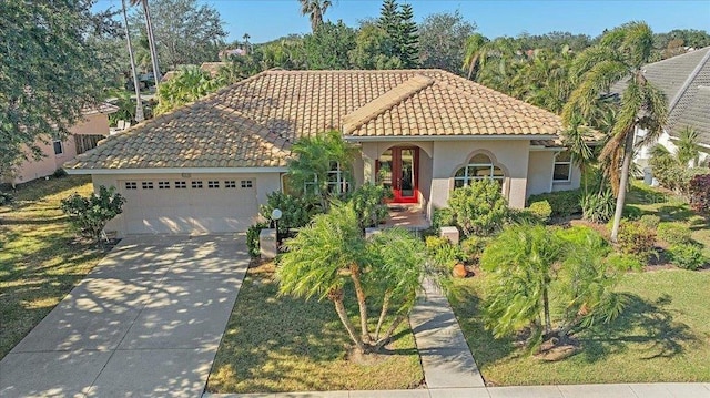 4978 Cedar Oak Way, Sarasota, FL 34233 - mediterranean / spanish-style house with stucco siding, a garage, driveway, and a tile roof