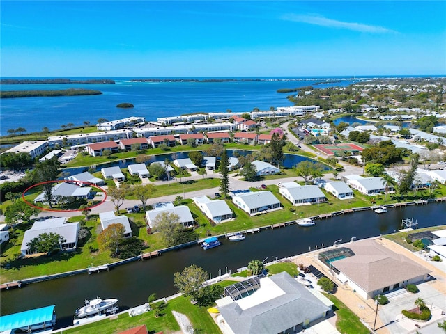 aerial view of property and surrounding area with a large body of water and nearby suburban area