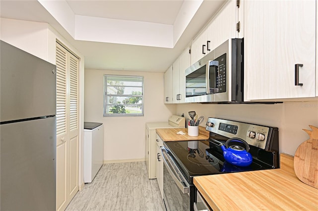 kitchen with stainless steel appliances, light wood finished floors, white cabinetry, baseboards, and wood counters