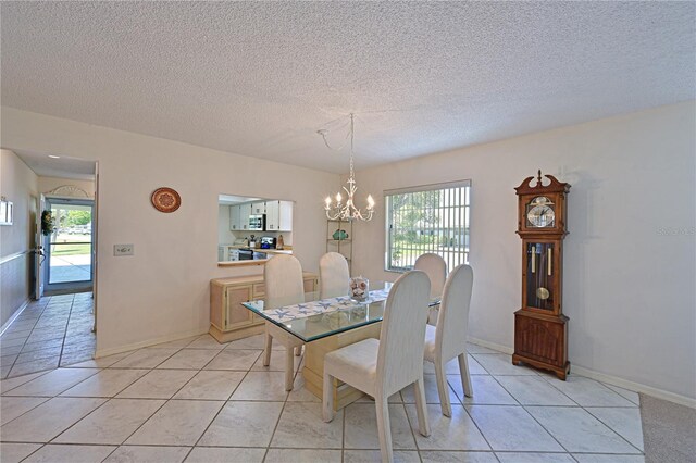 dining space with a chandelier, light tile patterned flooring, a textured ceiling, and baseboards