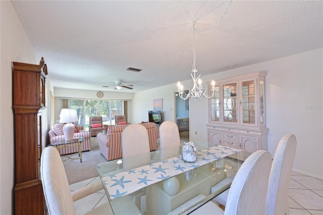 dining area with a textured ceiling, a chandelier, light tile patterned floors, a ceiling fan, and baseboards