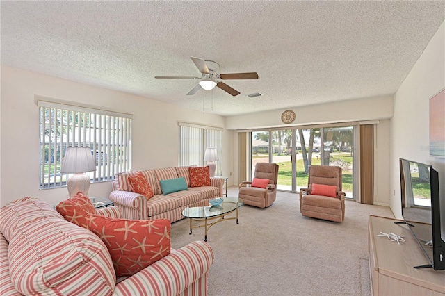 living room featuring light carpet, a textured ceiling, and a ceiling fan
