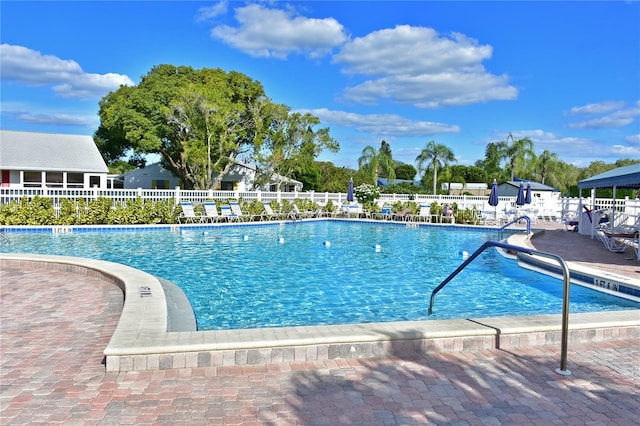 community pool with fence and a patio area