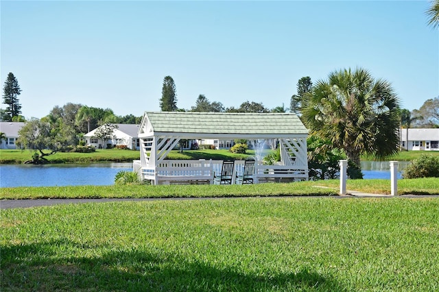 view of property's community with a yard, a water view, and a gazebo