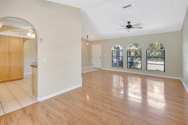 3510 Shawn St, Punta Gorda, FL 33980 - empty room with ceiling fan, arched walkways, light wood-style flooring, and baseboards