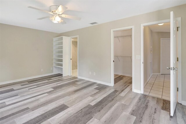 3510 Shawn St, Punta Gorda, FL 33980 - unfurnished bedroom with light wood-type flooring, a spacious closet, a closet, baseboards, and ceiling fan