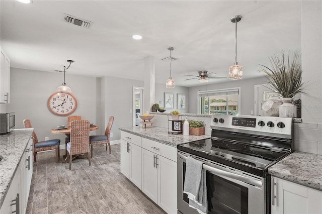 3102 16th Ave W, Bradenton, FL 34205 - kitchen featuring stainless steel appliances, white cabinets, ceiling fan, hanging light fixtures, and light wood-type flooring