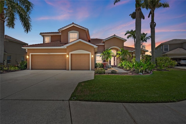 7626 Double Pine Dr, Sarasota, FL 34240 - mediterranean / spanish-style house featuring an attached garage, stucco siding, a yard, concrete driveway, and a tiled roof